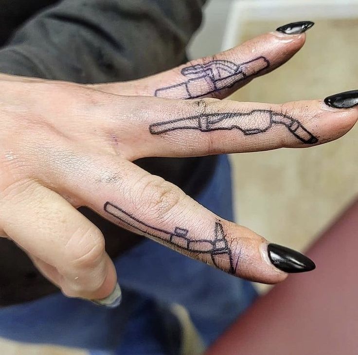 a woman's hand with a black and white tattoo on her left ring finger