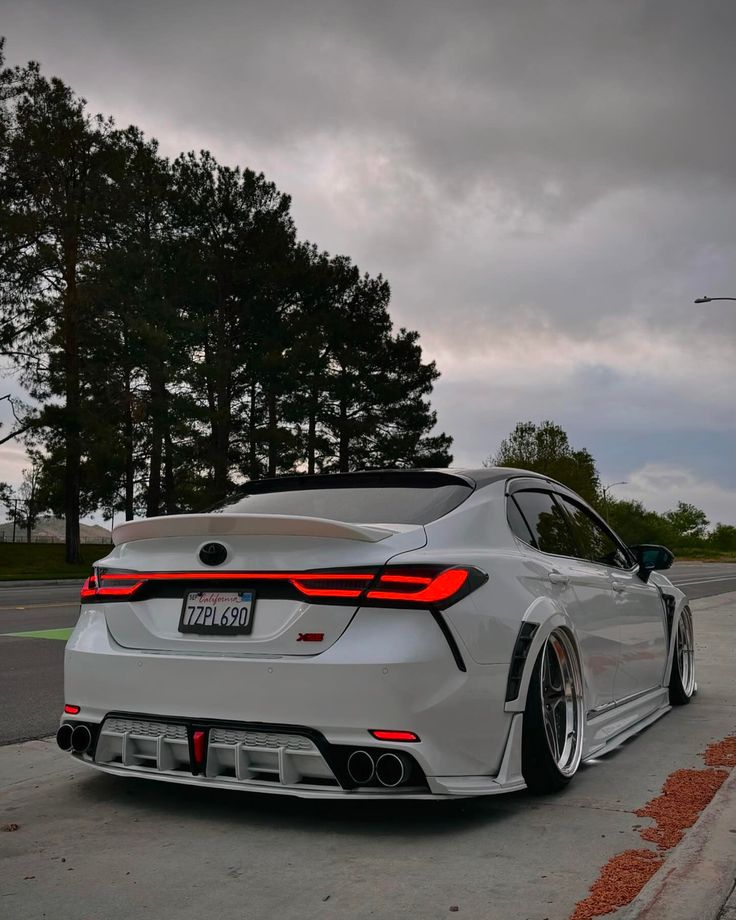 a white sports car parked on the side of the road