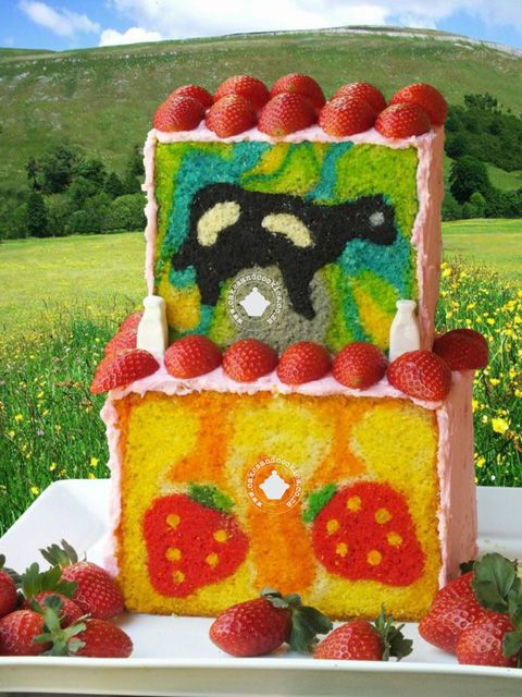 a cake made to look like a farm scene with strawberries on the table and grass in the background