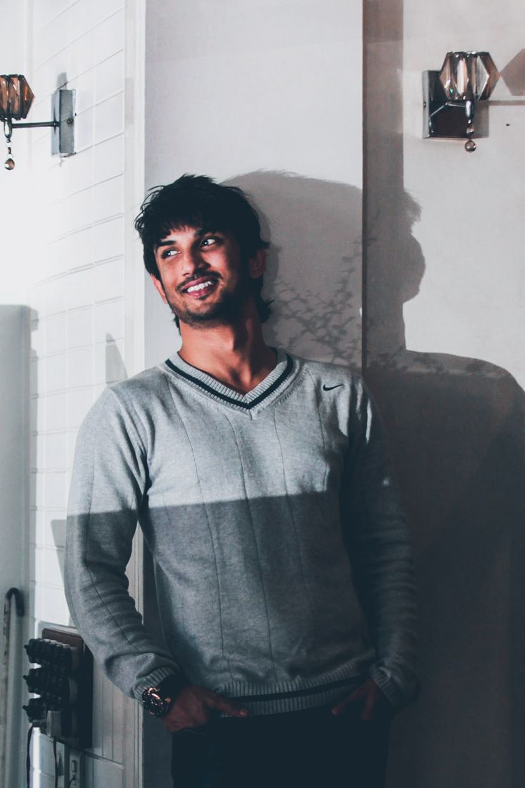 a man standing in front of a white wall