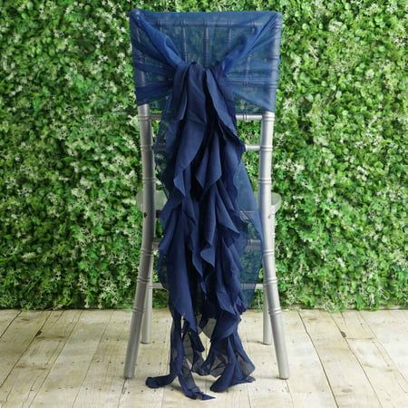 a chair covered in blue fabric sitting on top of a wooden floor next to a green wall