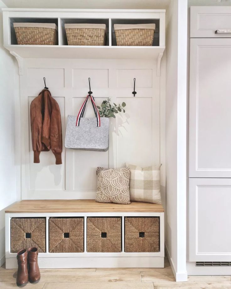 a coat rack with baskets and coats hanging on it's sides next to a door