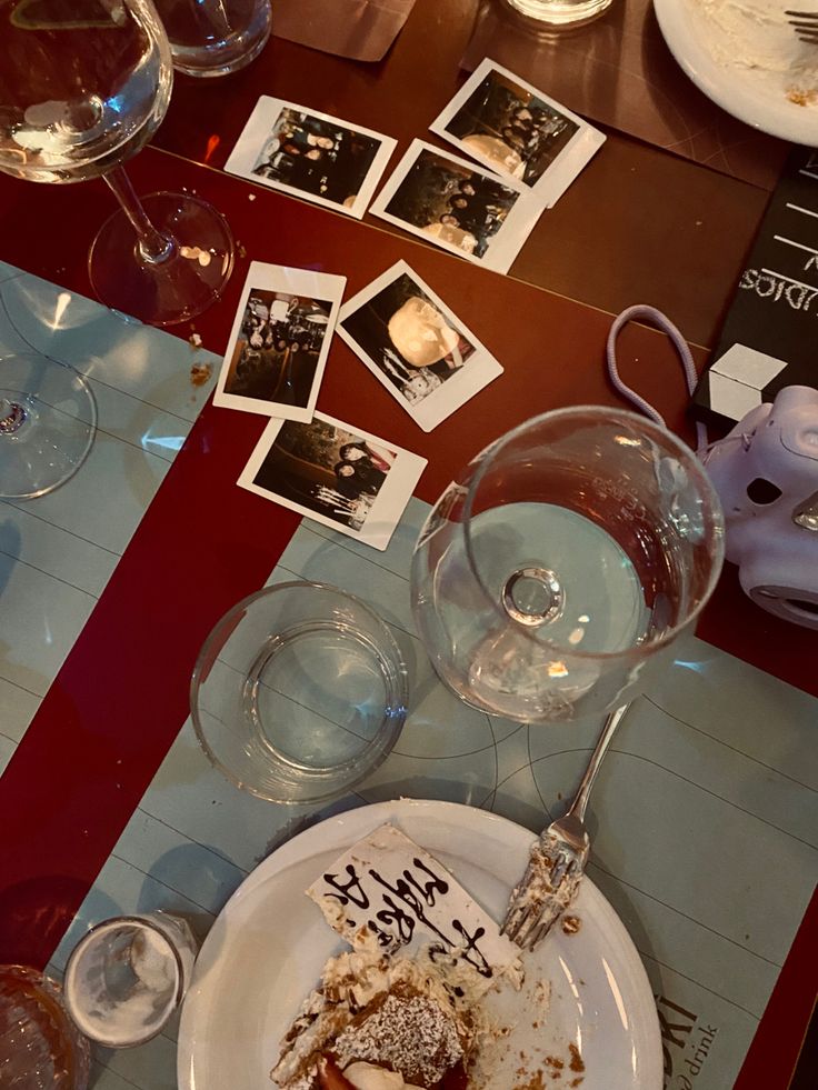 a table topped with wine glasses and plates filled with food