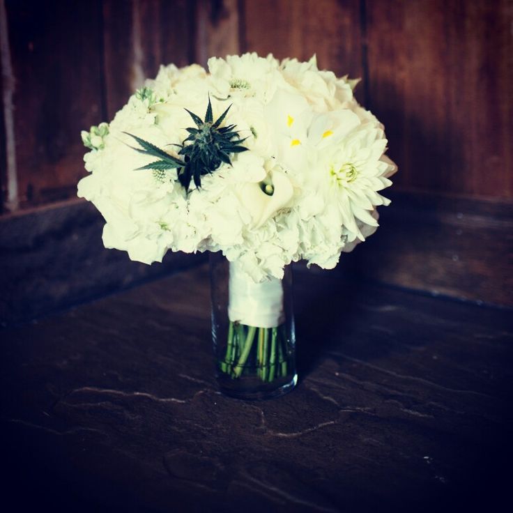 a vase filled with white flowers on top of a wooden table