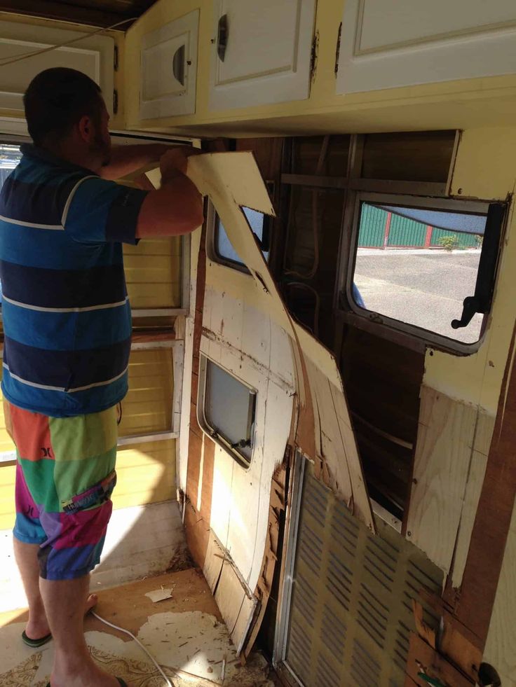 a young boy is standing in front of an rv door that has been torn open