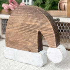 a wooden object sitting on top of a table next to a potted planter