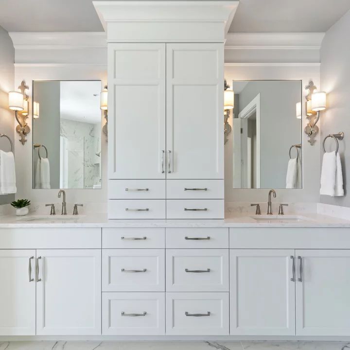 a white bathroom with double sinks and mirrors