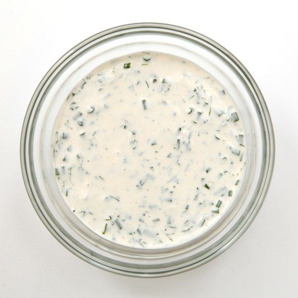 a glass jar filled with white sauce on top of a table