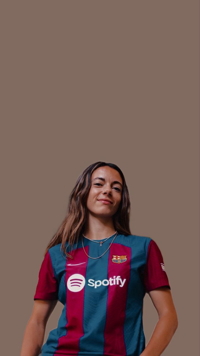 a woman in a blue and red soccer uniform poses for the camera with her hands on her hips