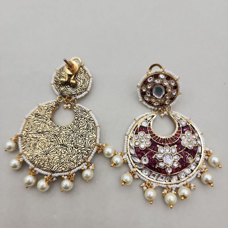 Elevate your bridal ensemble with these stunning Ruby and Pearl Chandbali Earrings. Designed as large chandbalis, they feature ruby stones complemented by pearl drops, creating a perfect blend of traditional elegance and modern sophistication. Ideal for bridal wear or special occasions, these earrings make a bold and luxurious statement. Length: 3" to 3.5" Material: 24Kt gold foil, lac Stones: Kundans, semi precious rubies, semi precious pearls, semi precious turquoise Chandbali Earrings, Ruby Stone, Pin Pendant, 24kt Gold, Pendant Rings, Pearl Drop, Natural Beads, Bridal Wear, Necklaces Bracelets