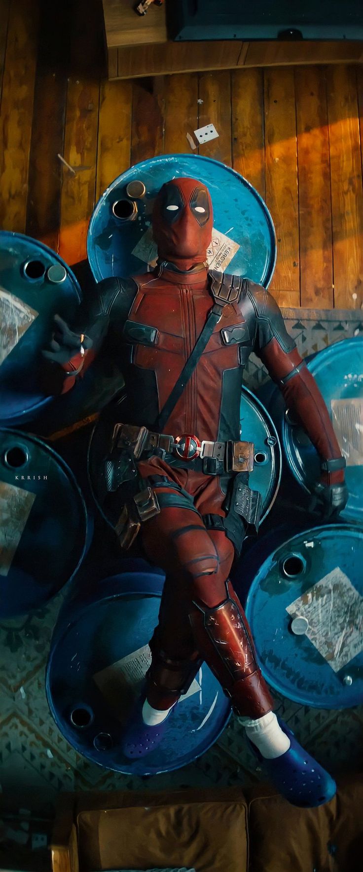 the deadpool character is sitting in front of some metal circles and looking like he's about to go into space