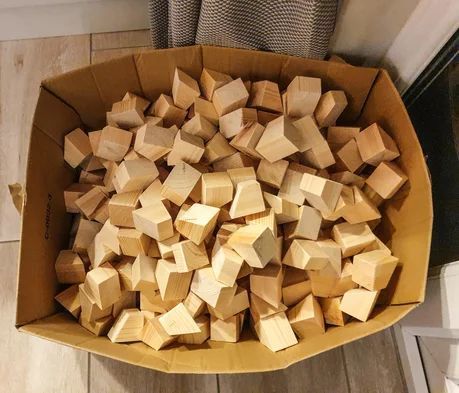 a cardboard box filled with wooden blocks on the floor