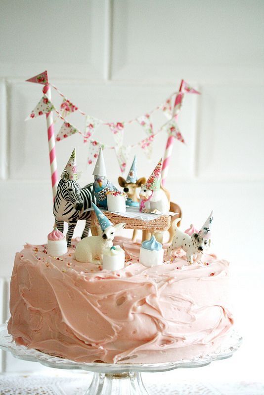 a cake with pink frosting and decorations on top