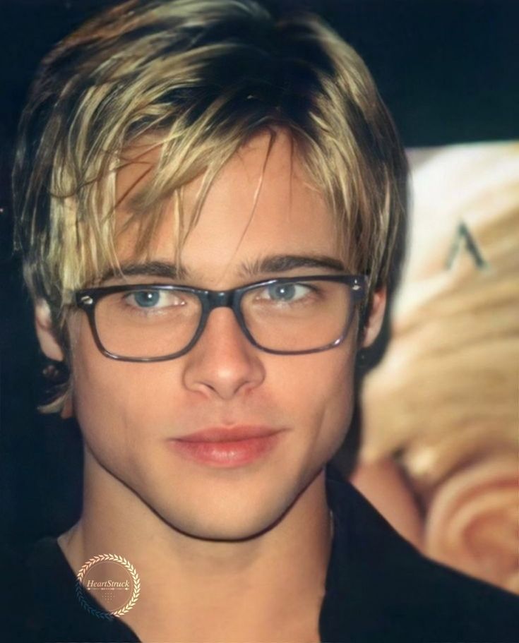 a young man with glasses is looking at the camera