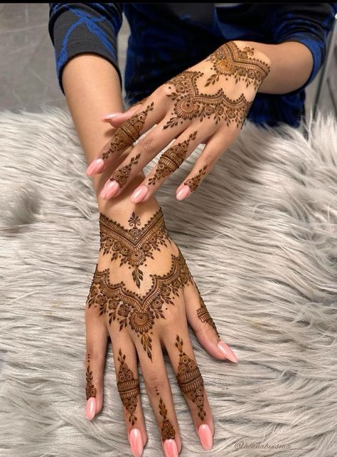 a woman's hands with hennap on it and her hand showing the intricate design