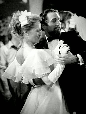 black and white photograph of bride and groom hugging each other in front of the crowd