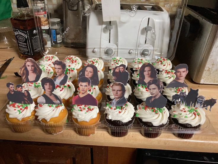 cupcakes decorated with the faces of actors are displayed in front of a coffee maker