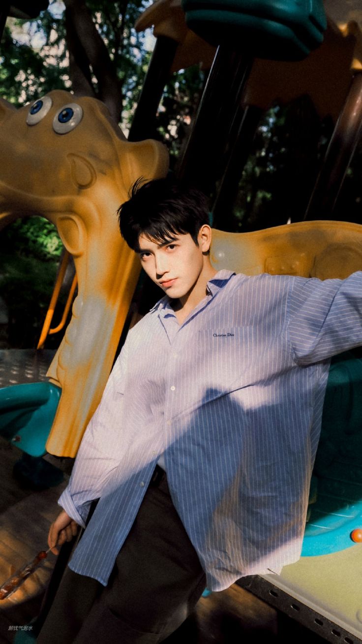 a young man standing in front of a carousel