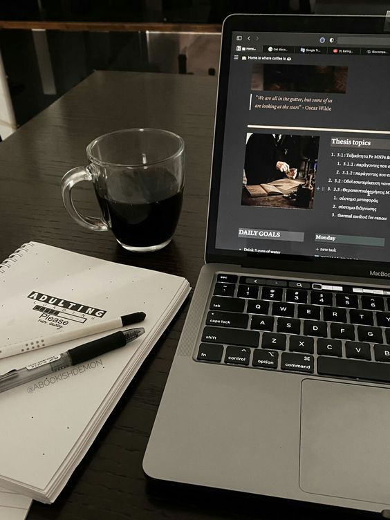 an open laptop computer sitting on top of a wooden table next to a cup of coffee