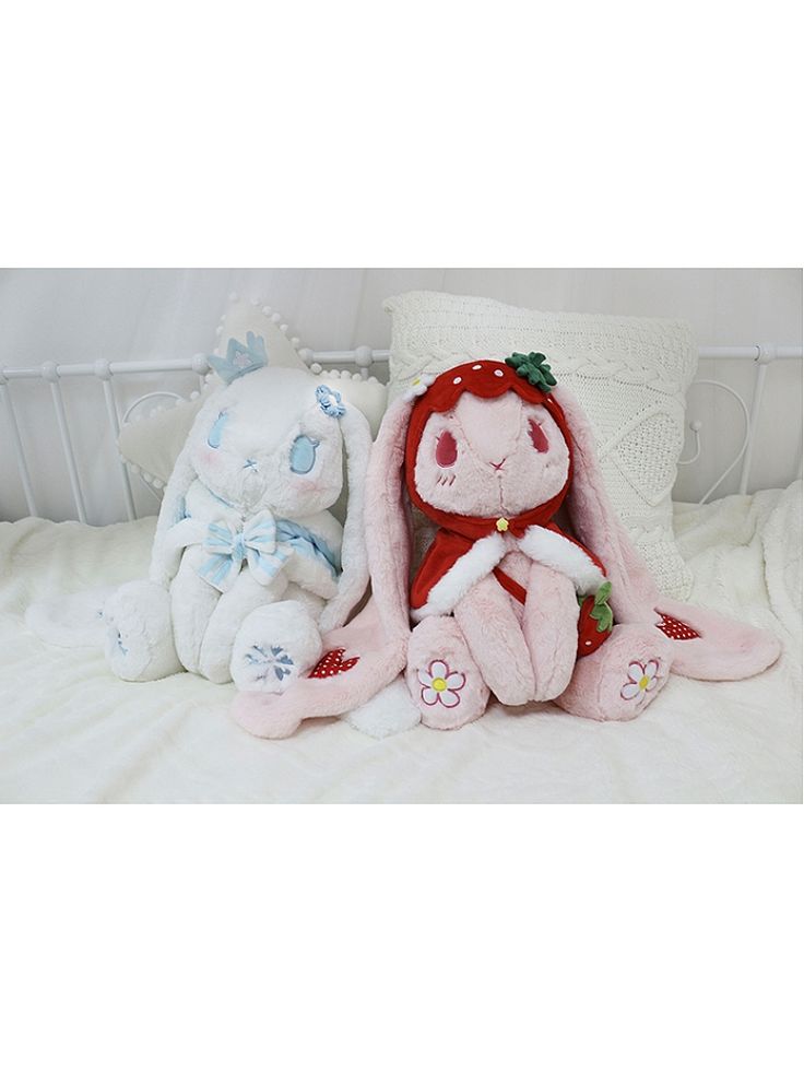 two stuffed animals sitting on top of a bed