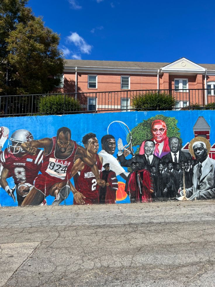 a large mural painted on the side of a building in front of a blue fence