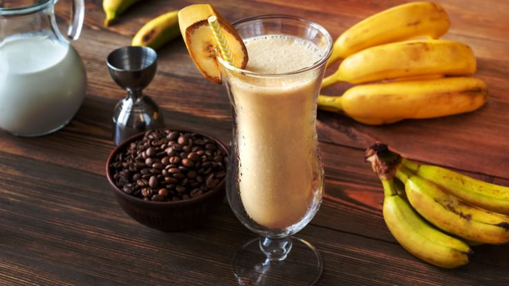 bananas, milk and other foods are on the table next to each other in glasses