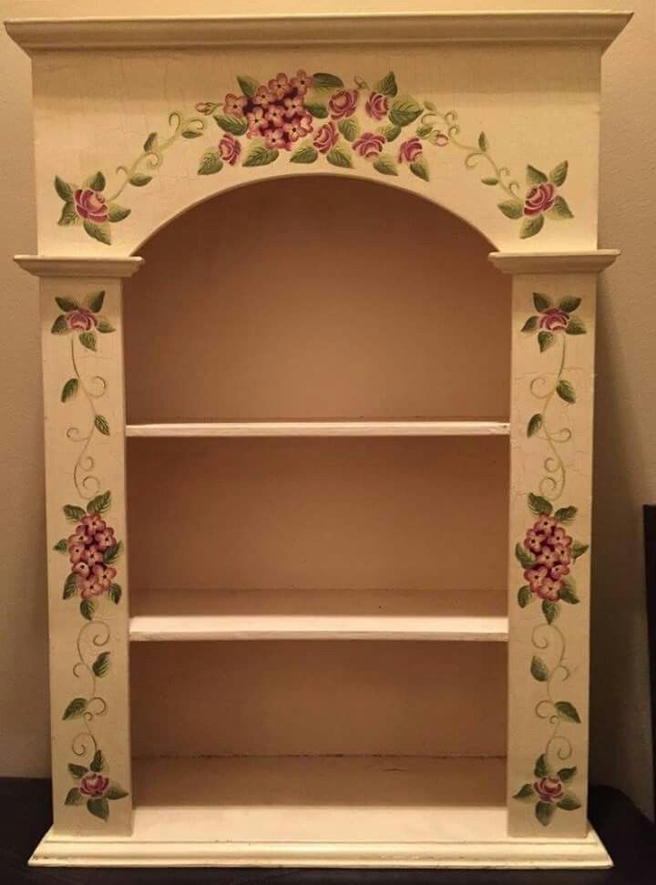 a white shelf with flowers painted on it