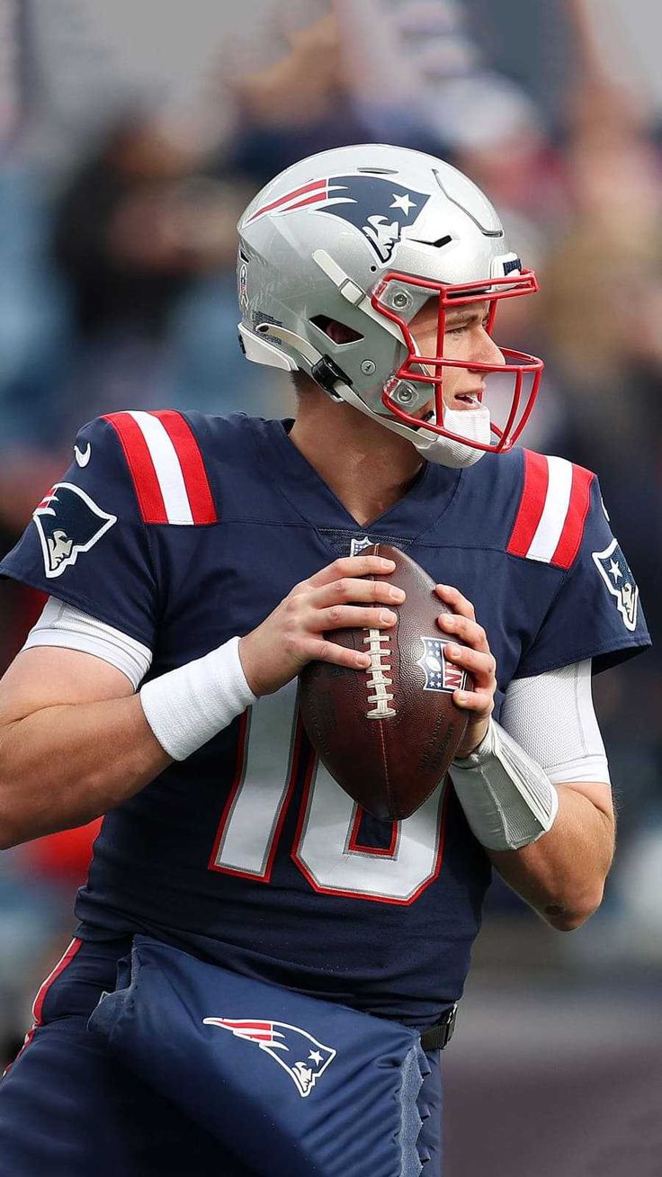 a man holding a football on top of a field