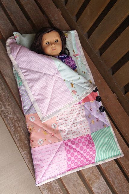 a doll is laying on top of a blanket that has been made into a quilt