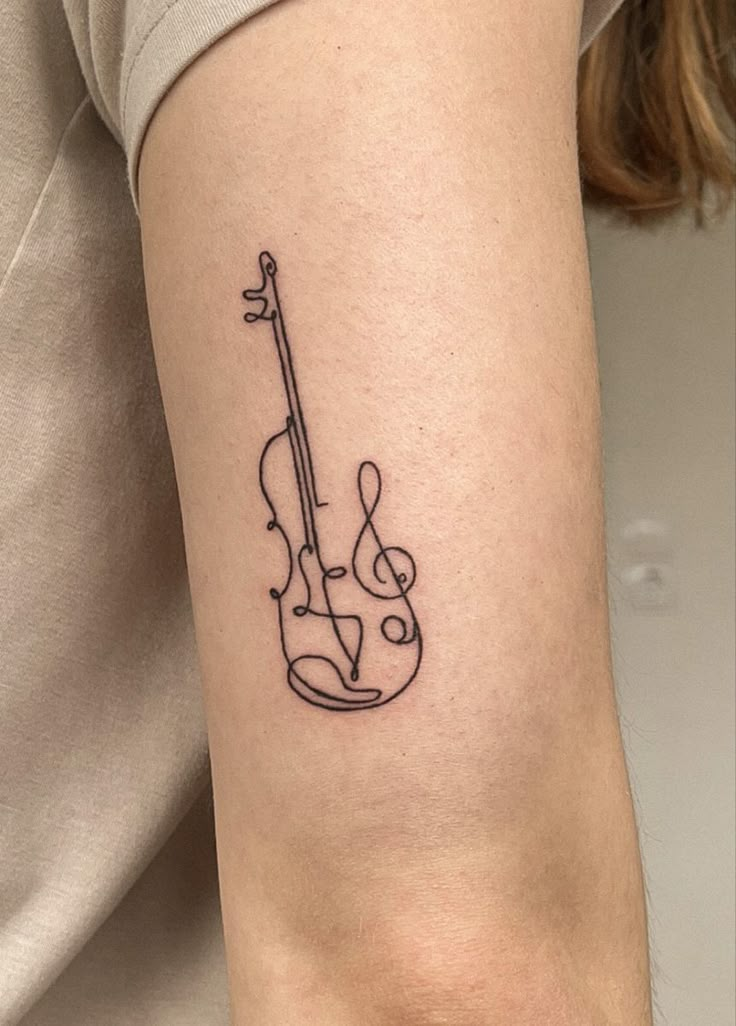 a woman's arm with a violin tattoo on the left side of her right arm