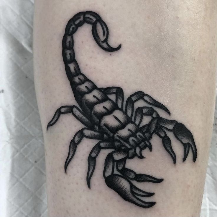 a black and white scorpion tattoo on the right leg, it looks like he's holding