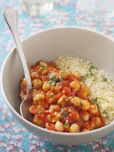 a bowl filled with rice and chickpeas on top of a blue table cloth