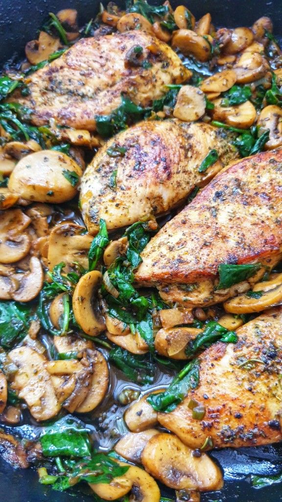 chicken with mushrooms and spinach in a skillet