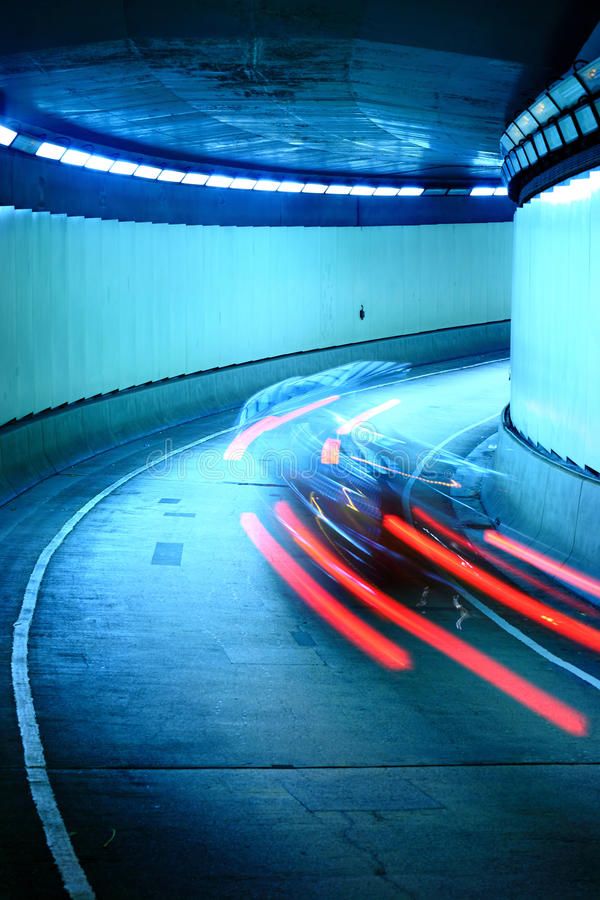 cars driving through a tunnel at night with bright lights in the background royalty illustration - stock image