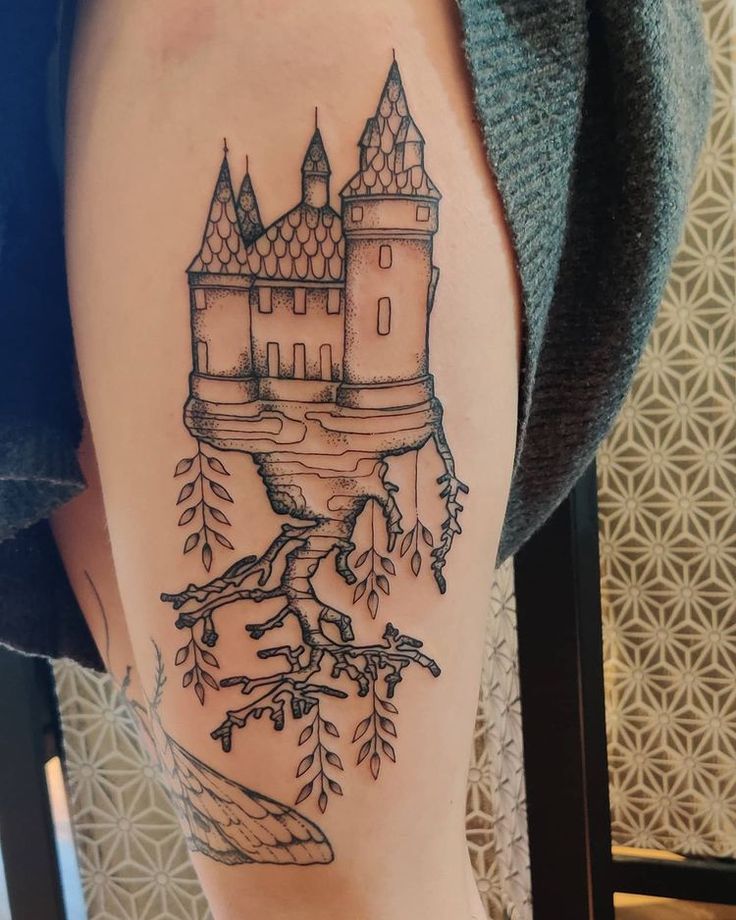 a woman's leg with a castle tattoo on it