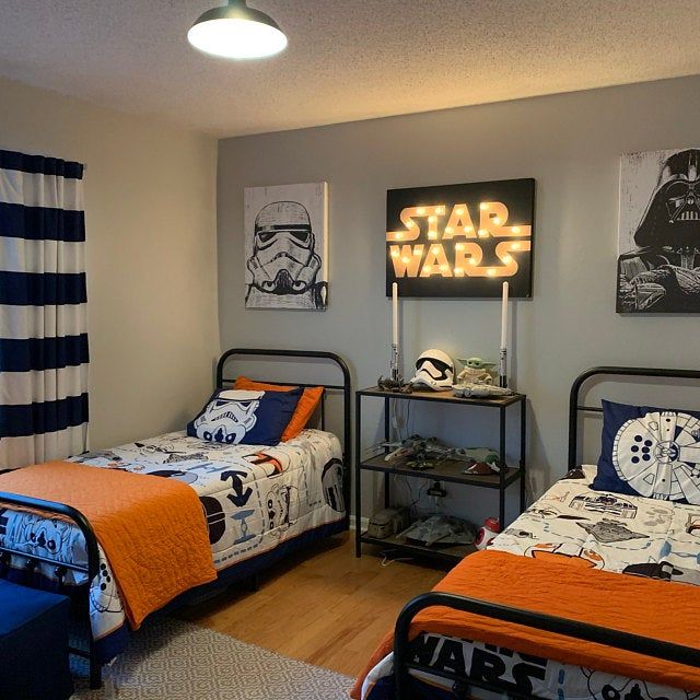 two beds in a room with star wars decorations on the wall