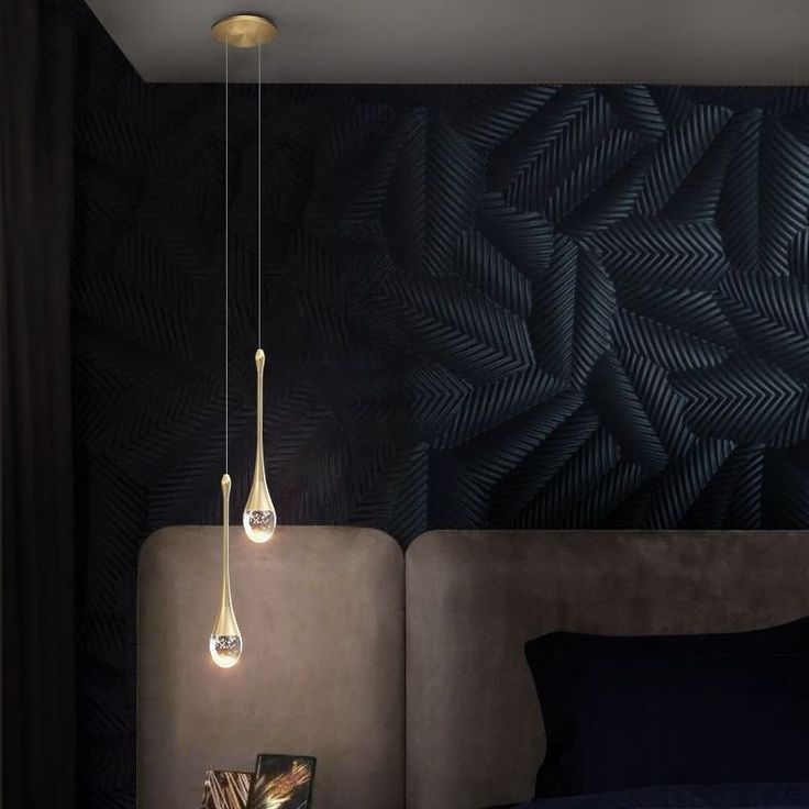 a bedroom with black and gold wallpaper, blue bedding and two hanging lights