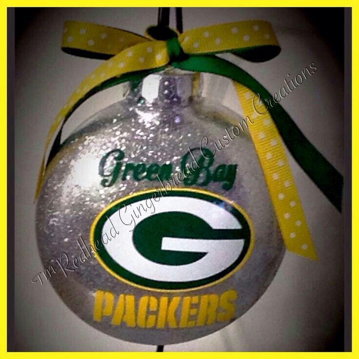 a green bay packers ornament hanging on a wall with a yellow ribbon around it