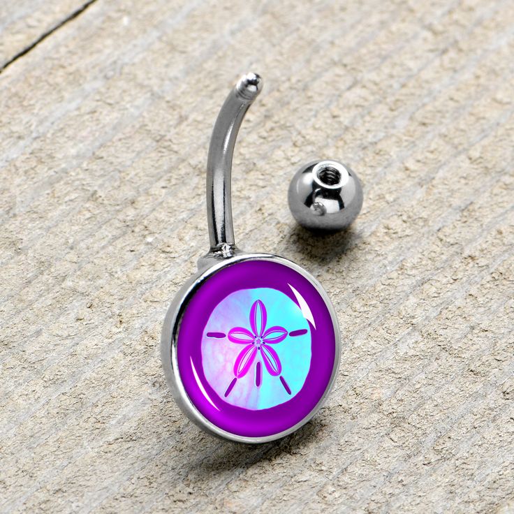 Product Details Hypoallergenic belly ring for sensitive skinPurple Nautical Sand Dollar Belly Ring You do not need a map to find treasure when you are rocking this 14 gauge sand dollar navel ring. It is made with a 7/16 inch 316L surgical grade stainless steel curved barbell with a 5mm top ball end. The bottom end features a pale blue sand dollar charm with purple detailing on a darker purple background. Every day is a day at the beach when you are rocking this striking sand dollar belly piercin Purple Internally Threaded Jewelry As A Gift, Purple Internally Threaded Jewelry Gift, Hypoallergenic Stainless Steel Belly Rings As Gifts, Purple Belly Piercing, Body Candy Belly Rings, Starfish Belly Button Ring, Nickel-free Stainless Steel Belly Rings As Gift, Nickel-free Stainless Steel Belly Rings For Gift, Nickel-free Round Stainless Steel Belly Rings