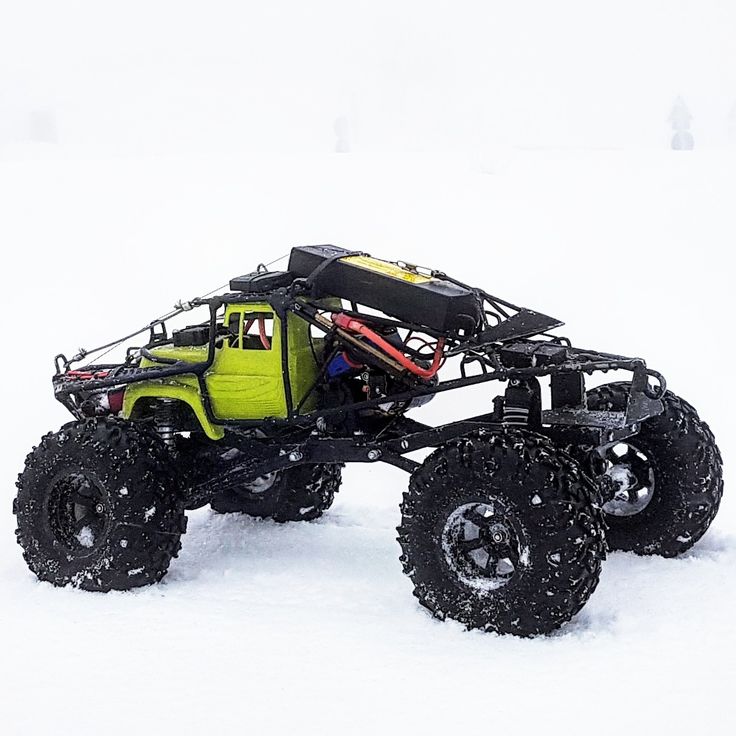 a yellow four - wheeled vehicle in the snow