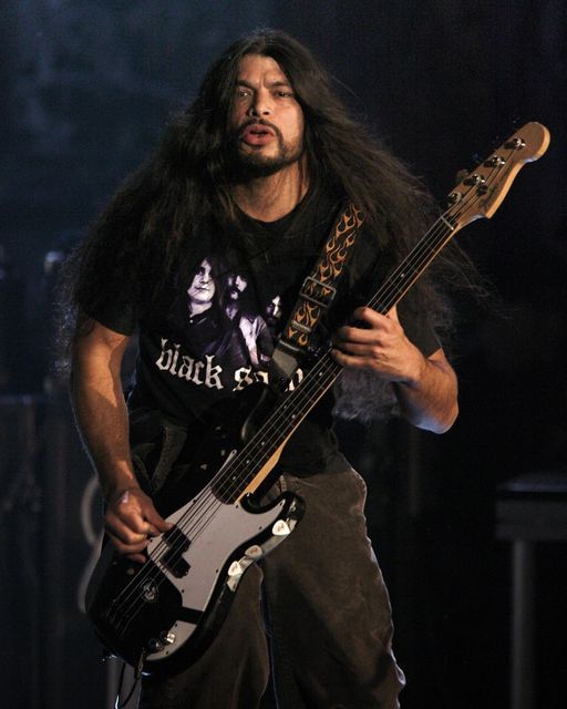 a man with long hair playing a guitar