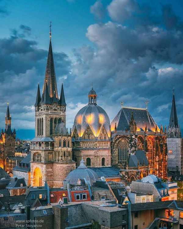 the cathedrals are lit up at night in this cityscape photo from across the river