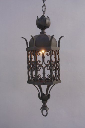 an old fashioned light hanging from a chain on a gray sky background with no clouds