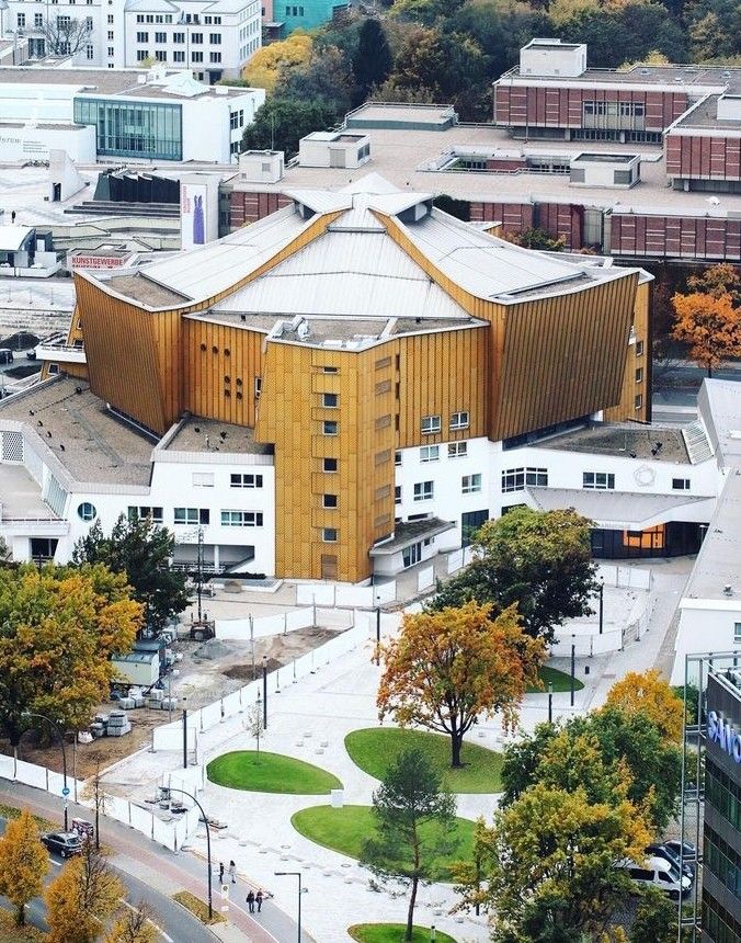 an aerial view of a large building in the middle of a city with lots of trees