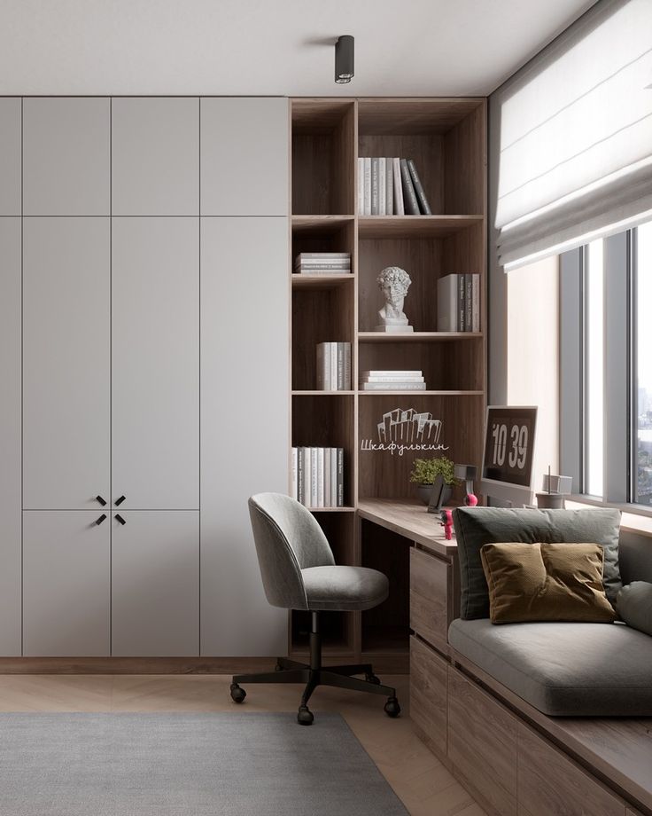 a room with a couch, desk and bookcases in the corner next to a window