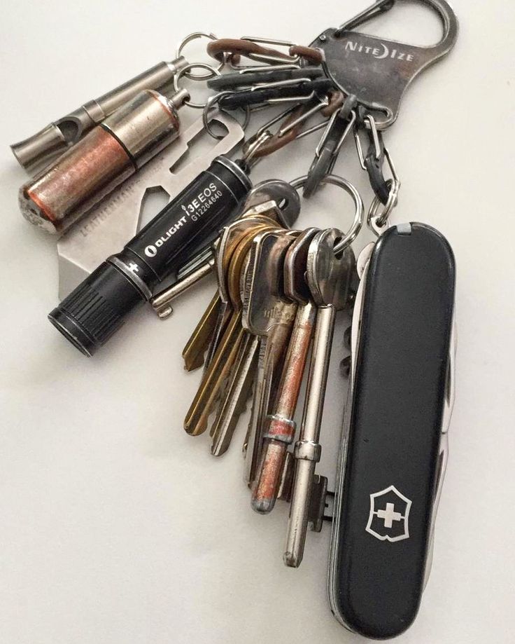 a bunch of keys that are laying on top of a keychain with a lighter