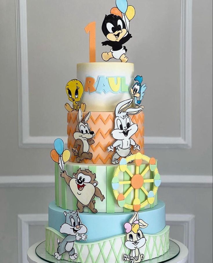 a three tiered cake with cartoon characters on it