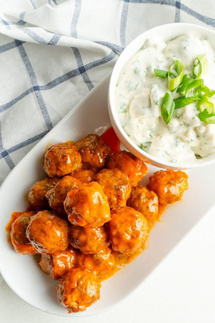 a white plate topped with tater tots next to a bowl of ranch dressing