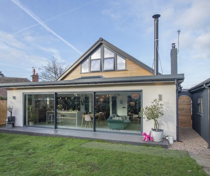 a house with large sliding glass doors on the front and side of it is shown