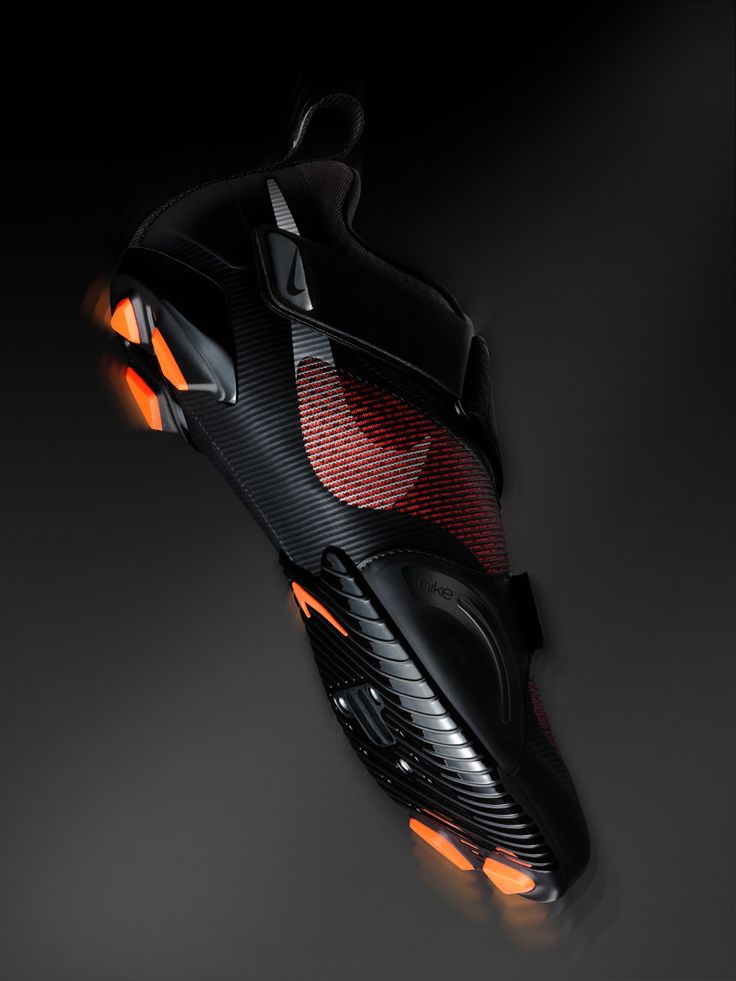 a pair of black and red shoes with orange lights on the soles, against a dark background